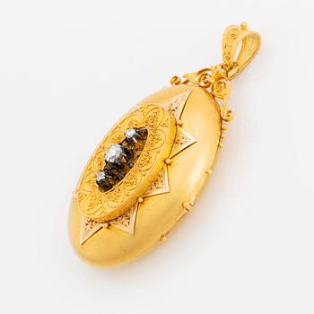 An 18K gold locket set with rose-cut diamonds.