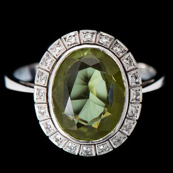 RING, fasettslipad peridot, åttkantslipade diamanter, 18K vitguld. Joensuun Kultaseppä, 1977.