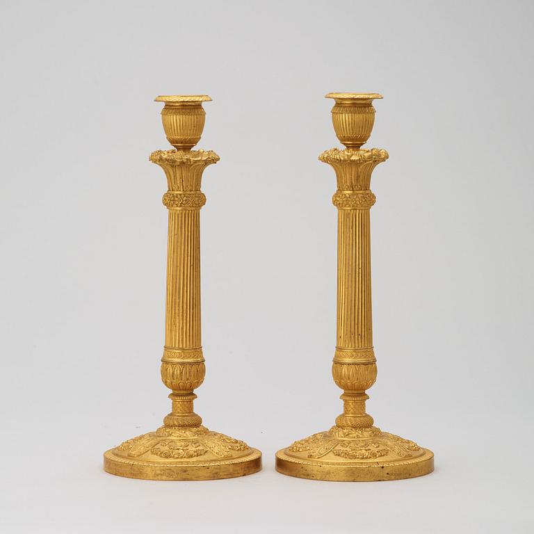 A pair of French Empire early 19th century gilt bronze candlesticks.