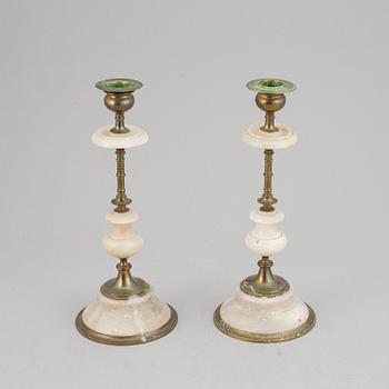 An alabaster mantle clock and pair of candlesticks, circa 1900.