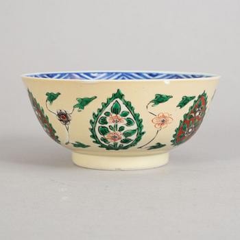 A blue and white bowl, the exterior in famille verte against a creme ground, Qing dynasty, Kangxi (1662-1722).