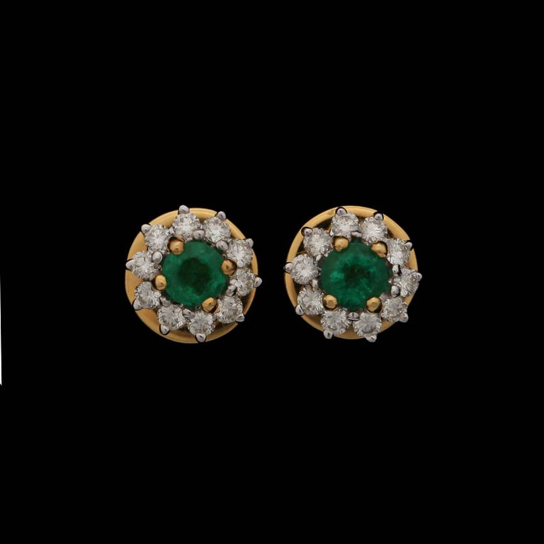 A pair of emerald earrings set with brilliant cut diamonds.