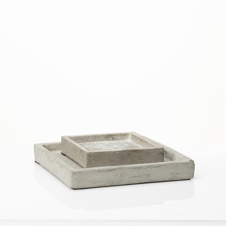 A mixed lot comprising a pair of limestone bookends, a bookshelf and two plates in concrete.