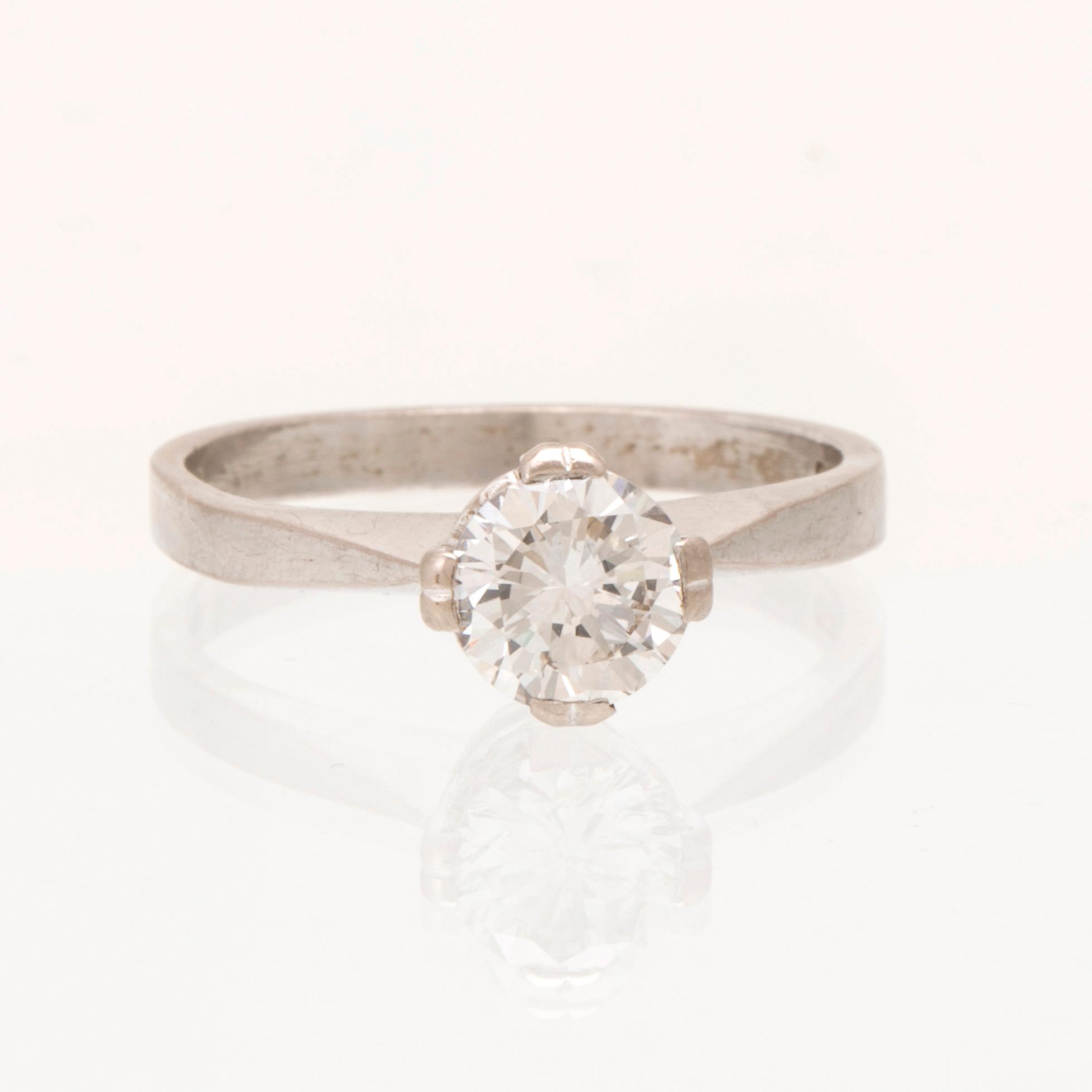 An 18K white gold solitaire ring set with a round brilliant cut diamond.