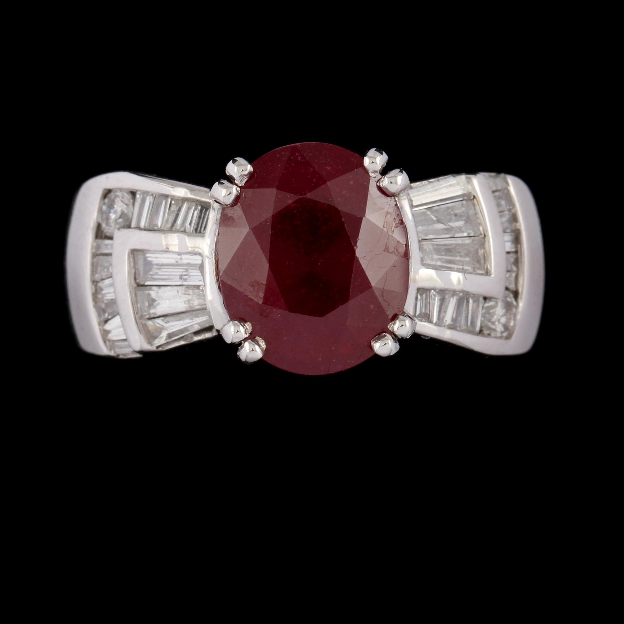RING, 14k vitguld med ovalslipad rubin ca 6.00 ct samt briljant och trapetsslipade diamanter, ca 1.00 ct. Vikt 10 g.