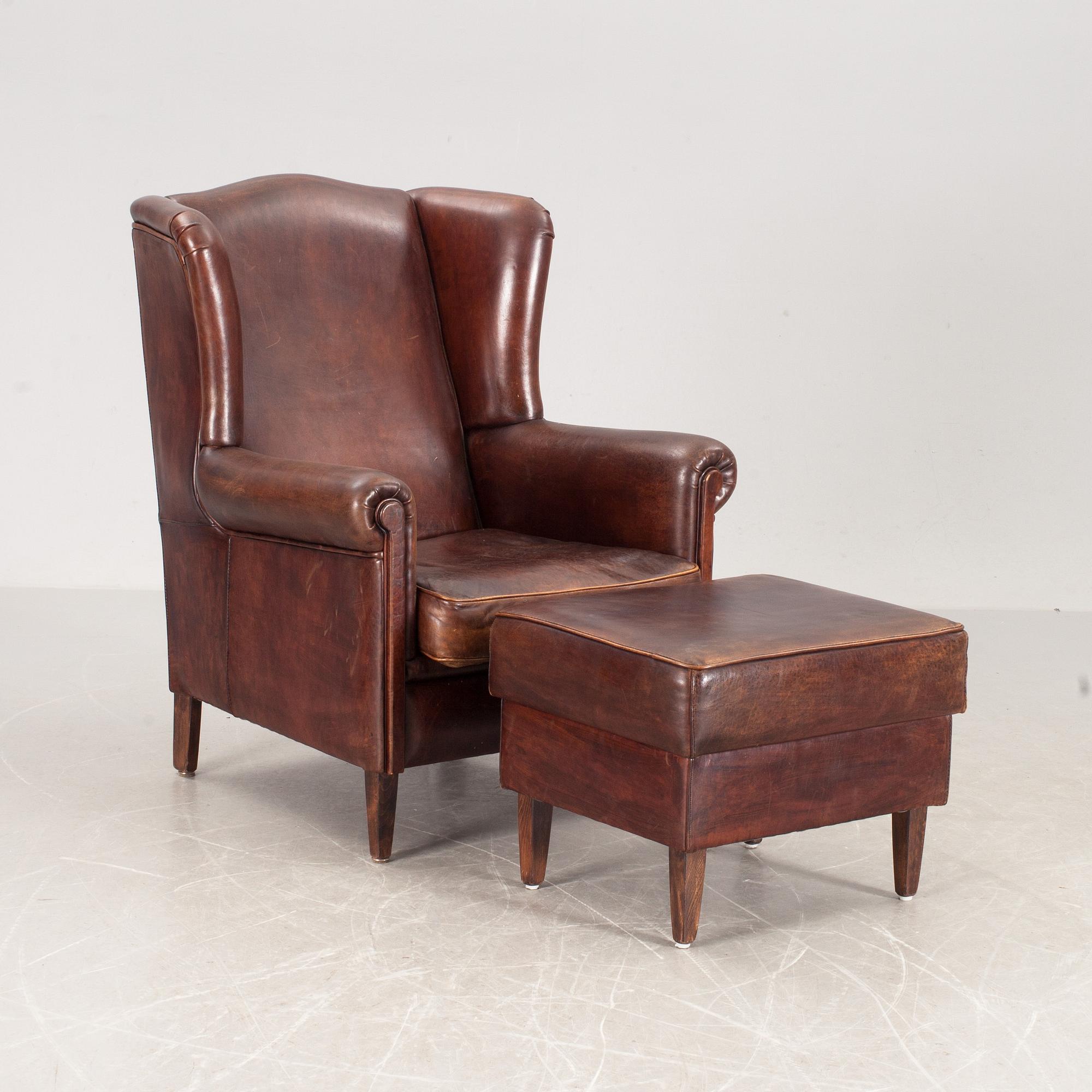 ÖRONLAPPSFÅTÖLJ samt FOTPALL, engelsk stil, 1900-talets fjärde kvartal.