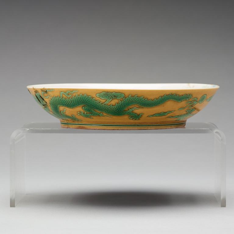 A yellow glazed dish with green five clawed dragons, Qing dynasty, Jiaqings seal mark in underglaze blue (1644-1912).