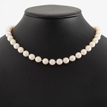 Pearl necklace, cultured pearls with a clasp in 18K white gold set with emeralds, diamonds, and pearls.