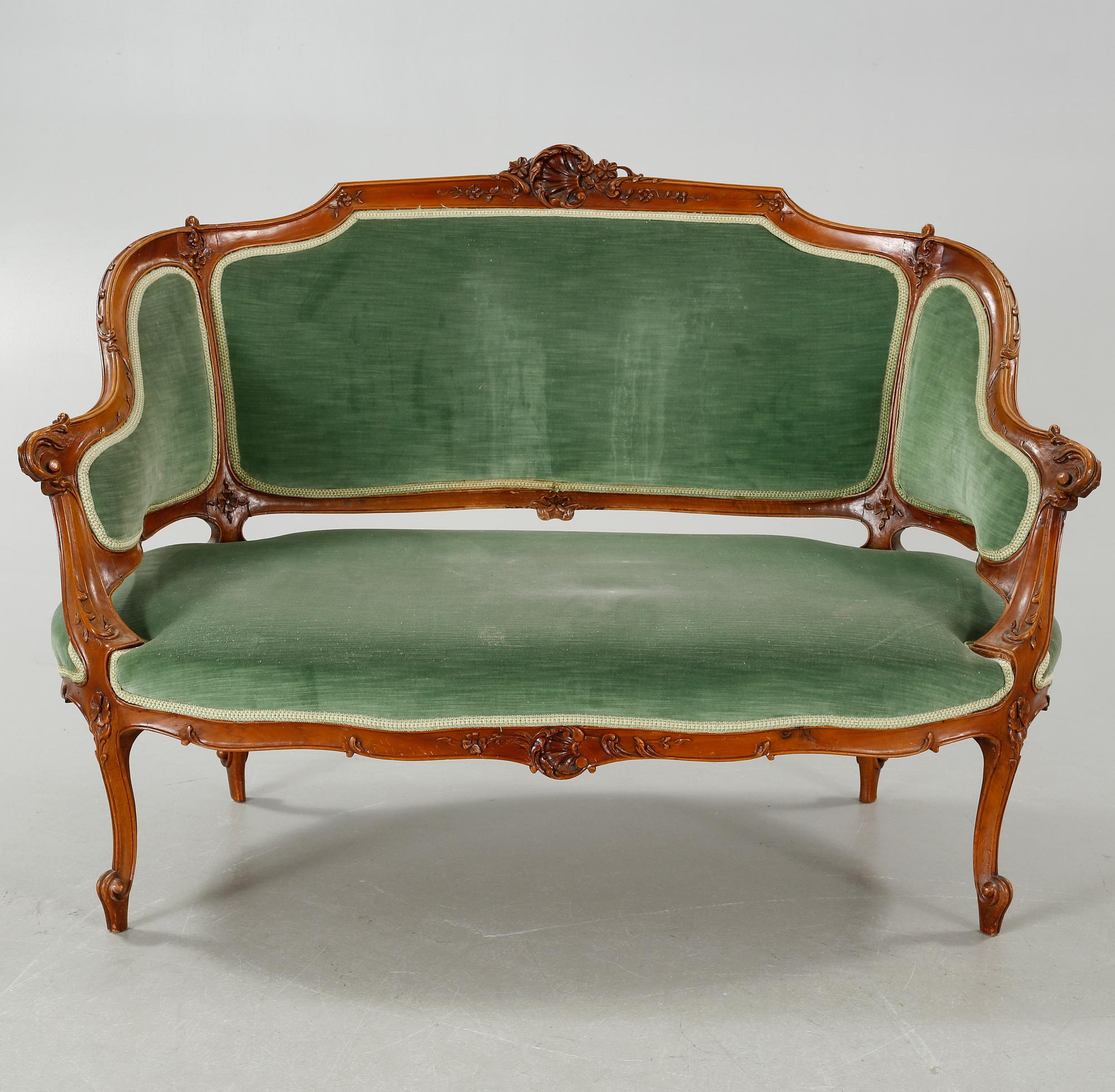 A rococo style sofa, two lounge chairs and a table, around the year 1900 and first half of the 20th century.