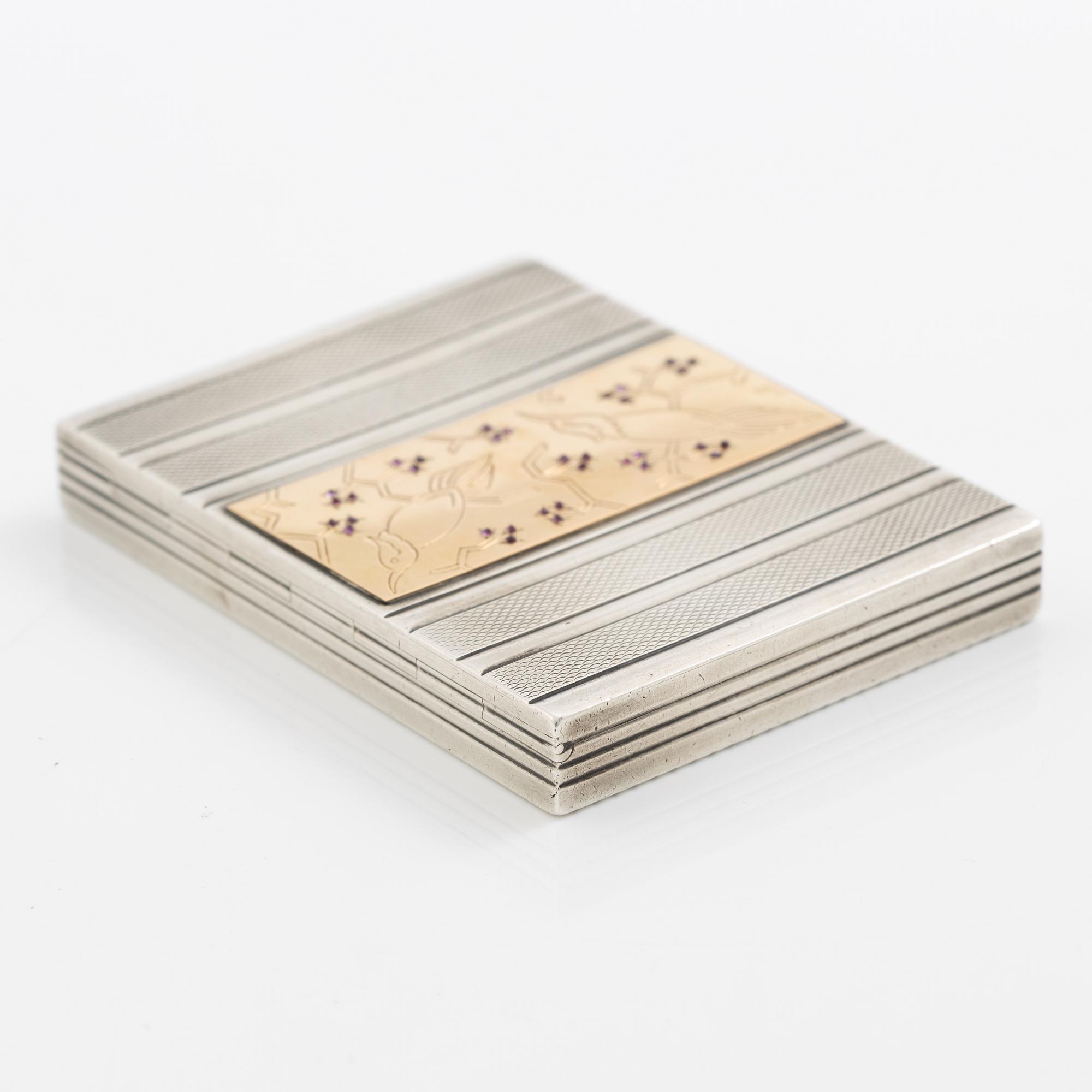 Puderdosa, silver samt guld. Med dekor av fåglar och rosa stenar.