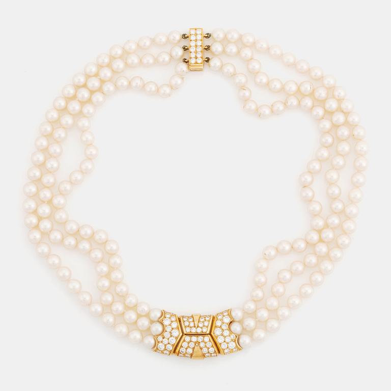 A Cartier triple strand cultured pearl necklace with an 18K gold clasp set with round brilliant-cut diamonds.