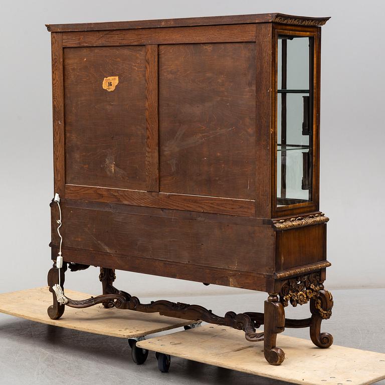 a baroque-style vitrine cabinet from the first half of the 20th century.