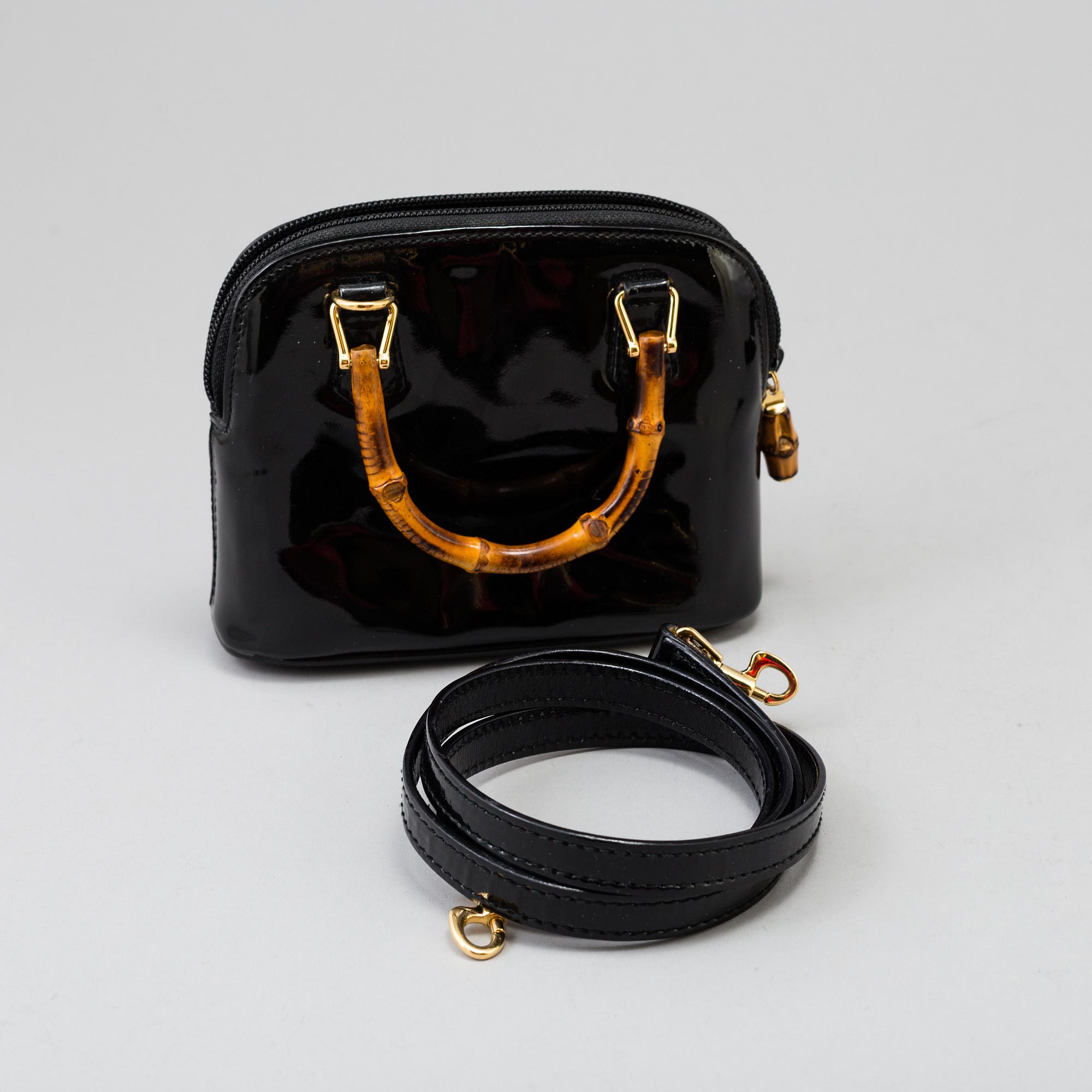 A Gucci patent leather bag with bamboo handle.
