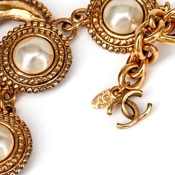 CHANEL, a gold colored metal necklace with white decorative pearls.