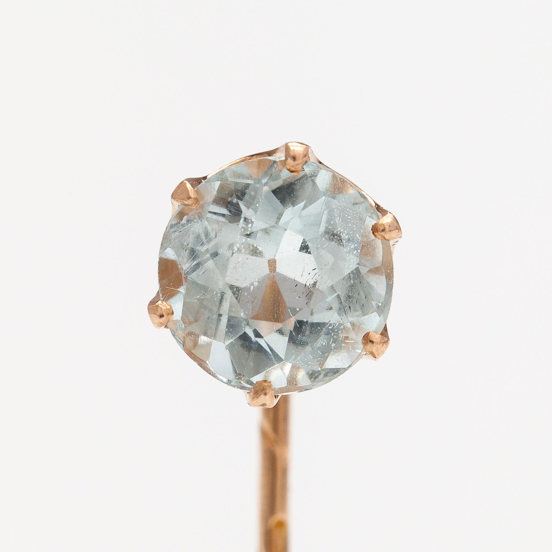 A 14K gold tiepin with a aquamarine.