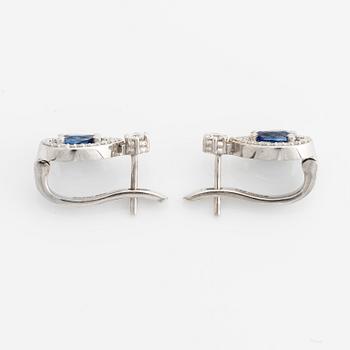 A pair of 14K gold earrings with faceted sapphires and round brilliant-cut diamonds.