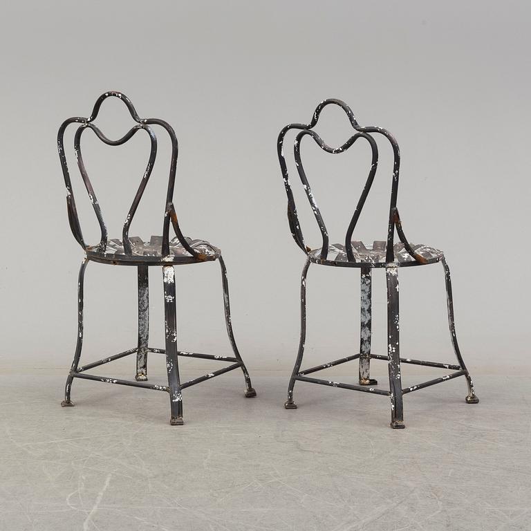 a pair of modern iron graden chairs,