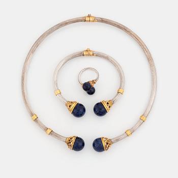 379. An Ilias Lalaounis demi parure comprising a necklace, a bracelet and a ring in silver and 18K gold set with sodalite.