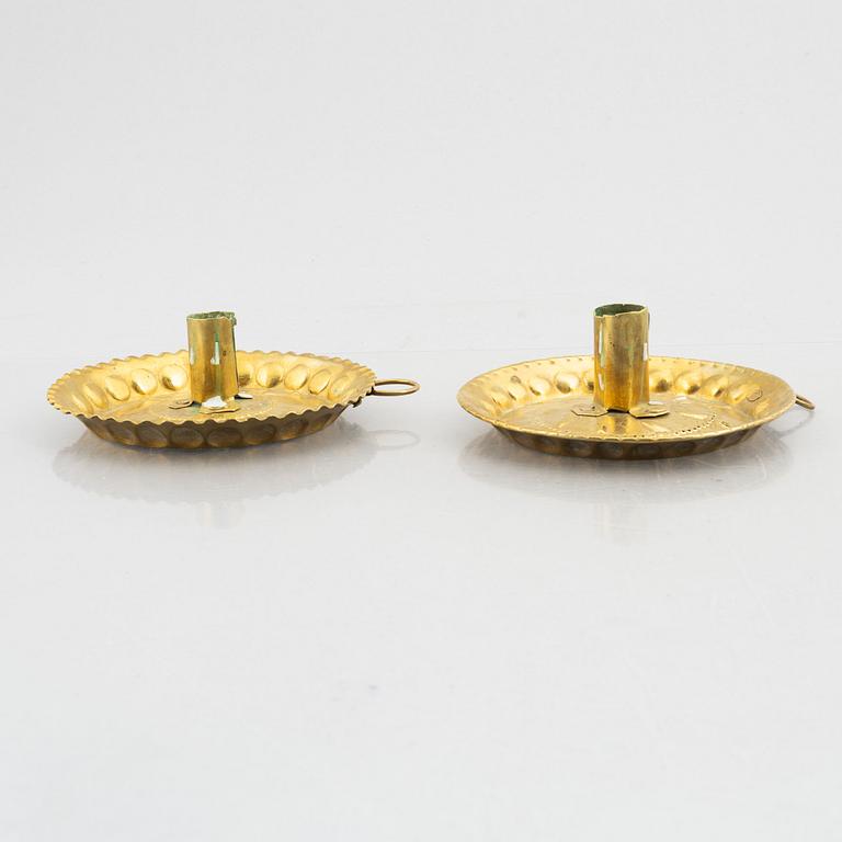 A set of three repousee brass candlesticks, 18th century.