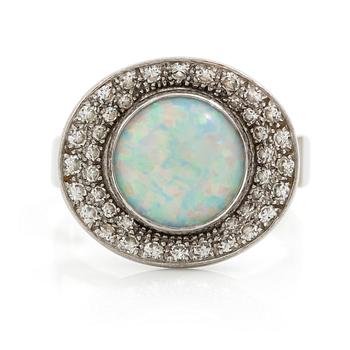 483. A ring 18K white gold set with an opal and eight-cut diamonds. CF Carlman, Stockholm 1973.