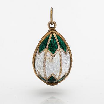 A gilded silver and enamel egg shaped pendant with a glass stone.