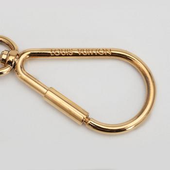 LOUIS VUITTON, a brass and lacquer key ring / bag charm, "Puzzle".