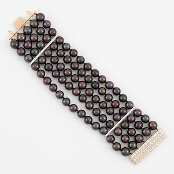 Bracelet with five rows of cultured black pearls, clasp in 18K gold and white gold set with brilliant-cut diamonds.