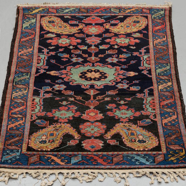 A RUG, an old Kurdish probably, ca 140,5-143,5 x 94,5-102 cm (as well as 2 cm flat weave at each end).