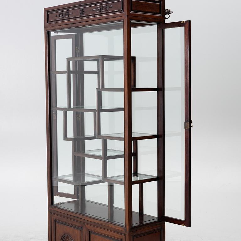A Chinese display cabinet, wood and glass, later part of the 20th century.