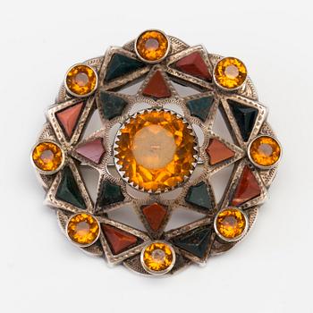 A BROOCH set with amber-coloured paste, heliotrope and jasper.
