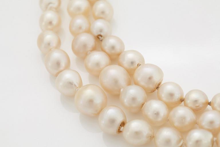 A three strand cultured pearl necklace with a clasp in 18K gold and silver set with rose- and old-cut diamonds.