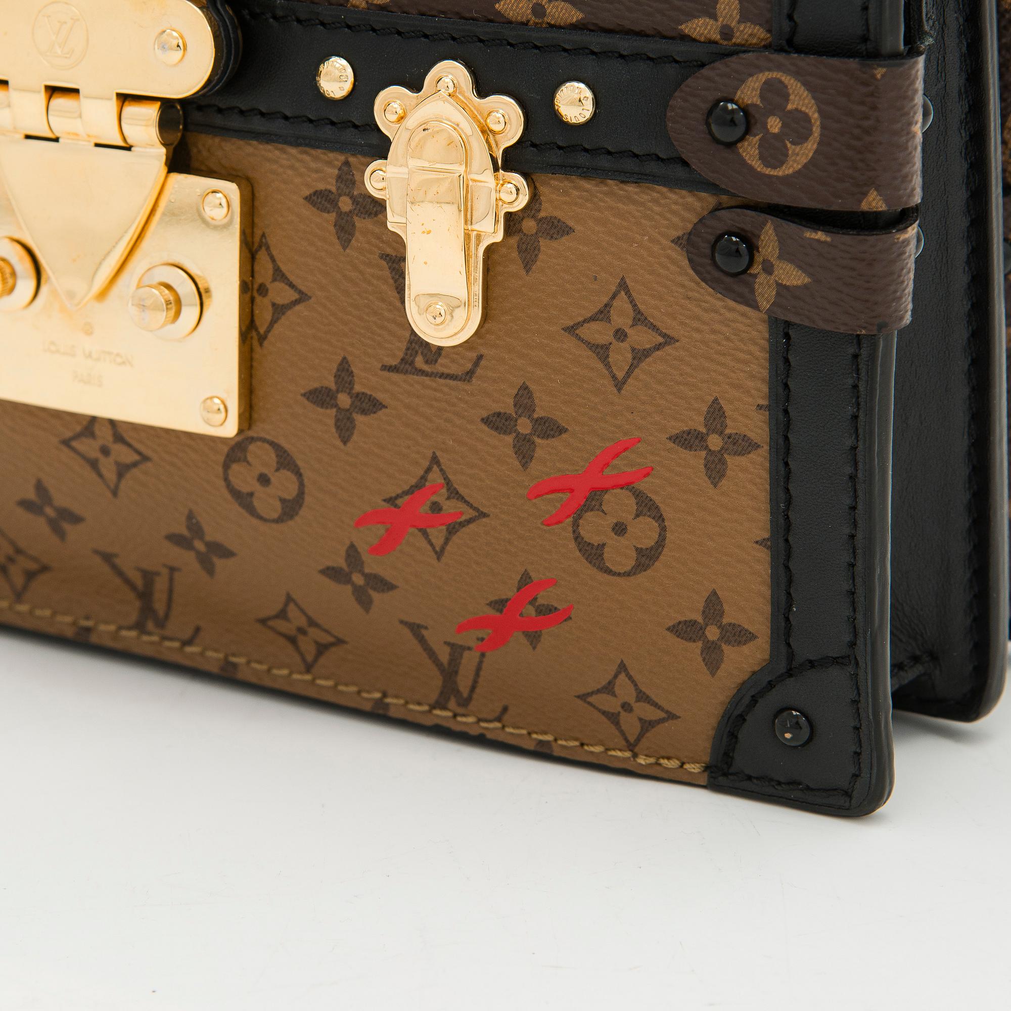 Louis Vuitton, a "Reverse Monogram Trunk Clutch" bag.