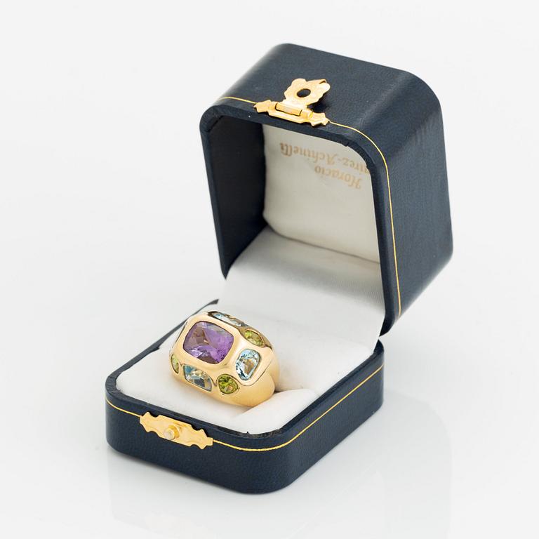 An 18K gold ring set with faceted amethyst, peridot and aquamarine.