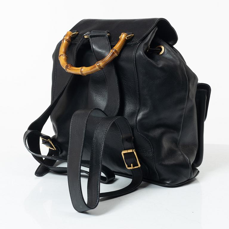Gucci, A black leather backpack.