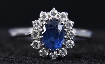 CARMOSERING, vitguld, 12 st briljanter samt safir. 1.01 ct enl inskription.