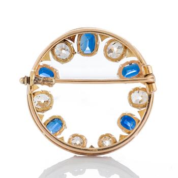 A brooch in 14K gold set with old- and rose-cut diamonds and faceted sapphires.