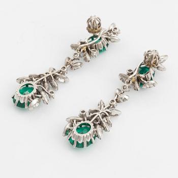 A pair of 18K white gold earrings set with round brilliant- and navette-cut diamonds and green synthetic stones.