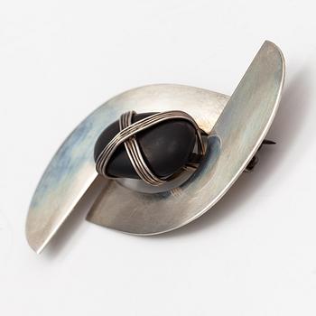 Paula Häiväoja, a sterling silver brooch with a natural stone "kiveen sidottu musta". Pentti Roos/Studio Paula, Helsinki.