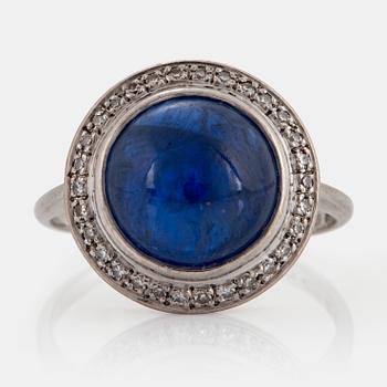 An A Tillander ring in 18K white gold set with a cabochon-cut sapphire and eight-cut diamonds.