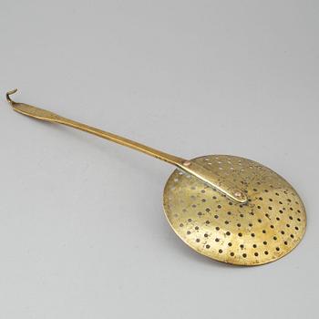 An 18th century brass strainer.