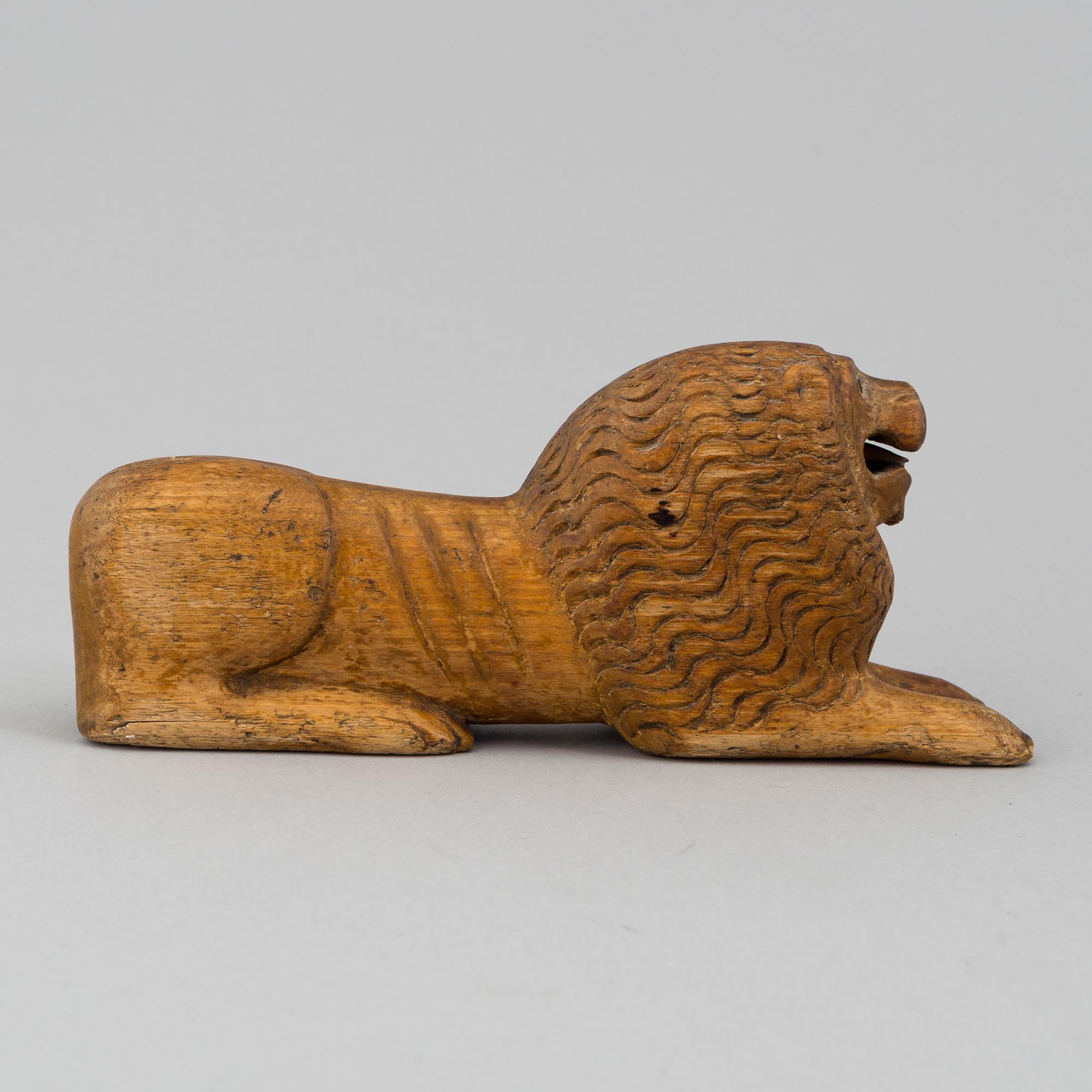 A carved wood sculpture of a lion from the 19th century.