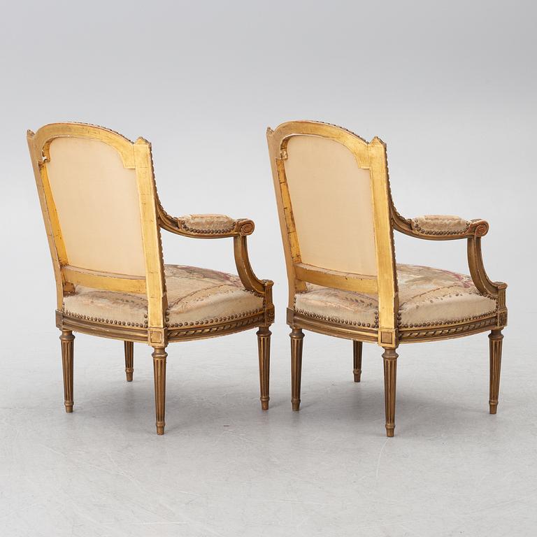 A pair of Louis XVI-style armchairs, late 19th century with 18th century fabric.
