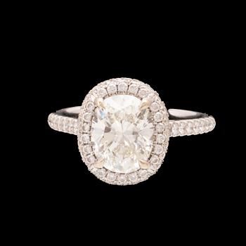 An 18K white gold ring by James Allen, set with an oval brilliant cut diamond in a halo of round brilliant cut diamonds.