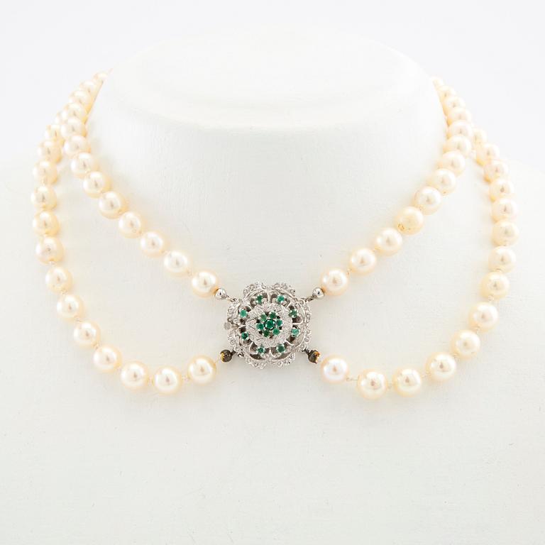 Necklace double-stranded of cultured pearls with a clasp of 18K white gold and emeralds.