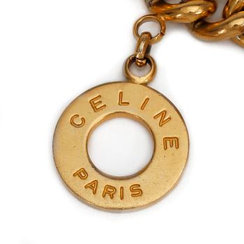 CÉLINE, a gold colored charm bracelet.