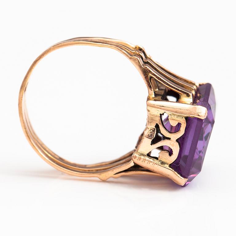 A 9-14K gold ring with a synthetic sapphire.