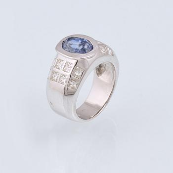 RING, 18K vitguld med ovalslipad blå safir ca 4.00 ct samt 16 prinsesslipade briljanter ca 1.50 ct. Vikt 15,9 gram.