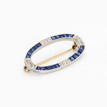 A platinum/14K gold brooch, set with sapphires and old-cut diamonds.