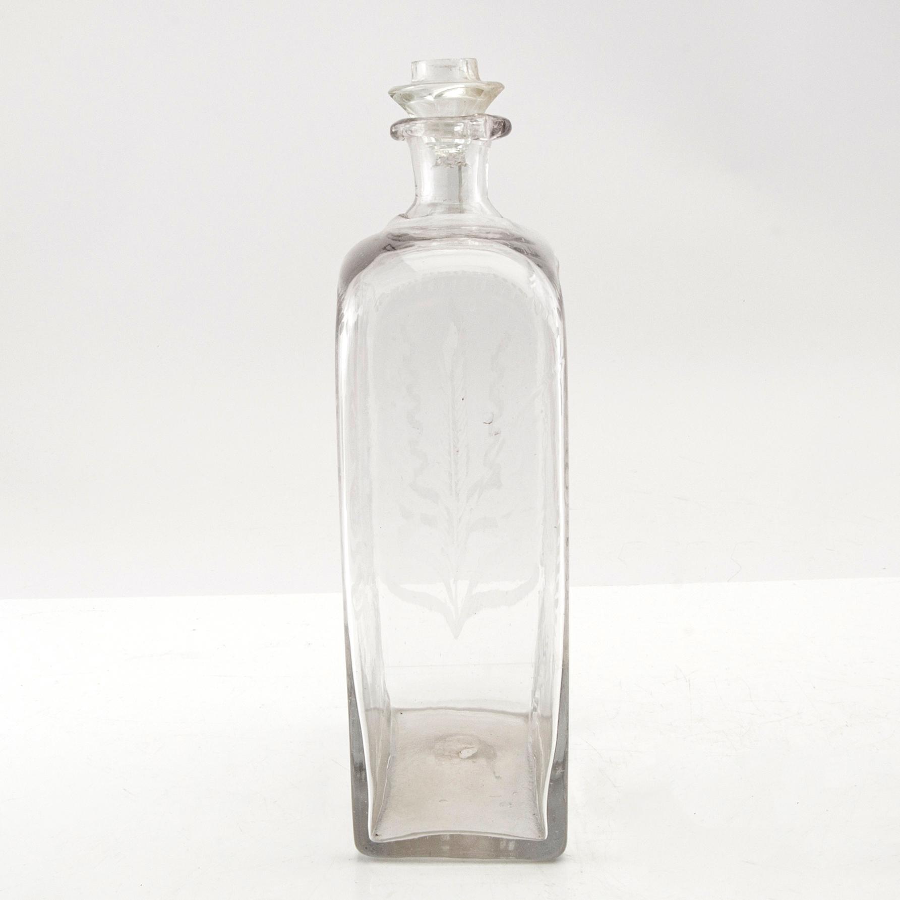 Brännvinsflaska, glas. Daterad Broby 1856.