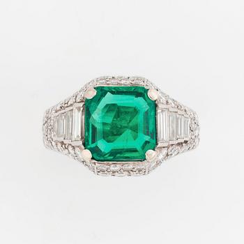 A Bulgari "Trombino" ring in platinum set with a step-cut emerald and round brilliant- and baguette-cut diamonds.